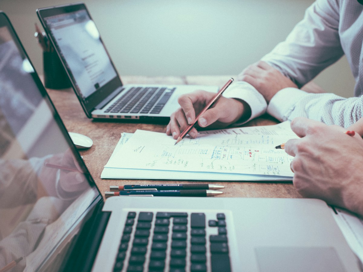 People checking paperwork together beside a laptop