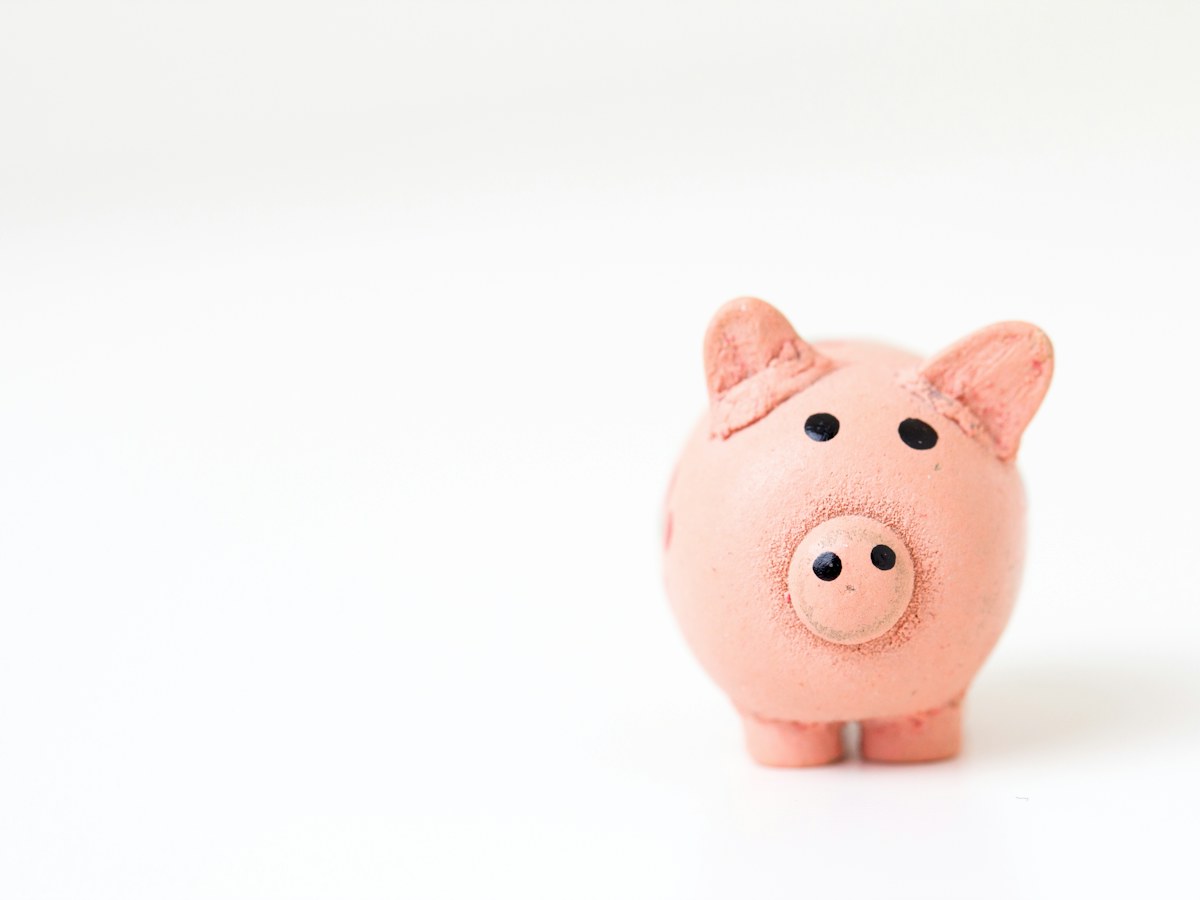 A pink ceramic savings bank on a white surface